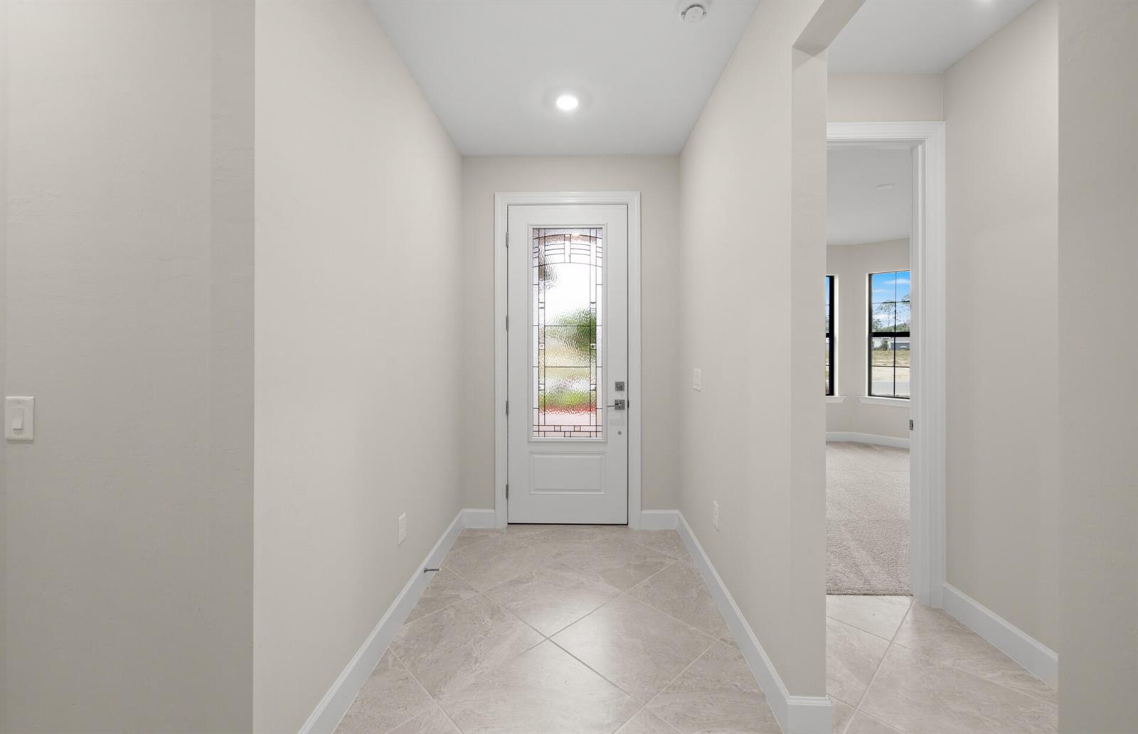 A tiled entryway features a white front door with a decorative glass insert — 3922 E Hampton Circle, FL 33920, FL