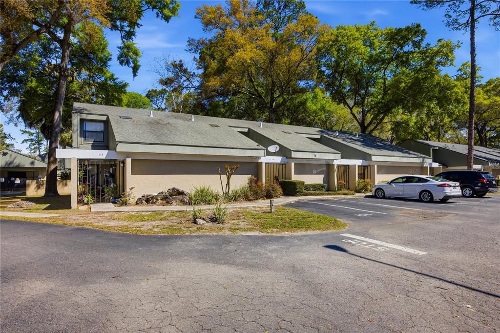 A single-story multi-unit residential building with a parking lot in the foreground — 7200 SW 8TH AVENUE UNIT S119, GAINESVILLE, FL