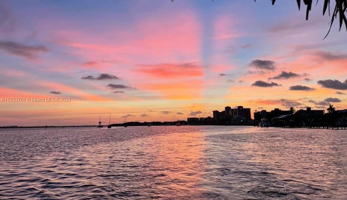 A view of a sunset over a body of water with buildings on the horizon — 2054 Applegate Ave, Port Charlotte FL 33953, PORT CHARLOTTE, FL