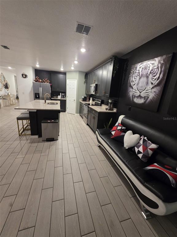 A kitchen with dark cabinetry, a central island, and a black sofa against the wall — 1431 SAGUARO STREET, DAVENPORT, FL