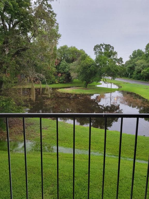 A view from a screened balcony overlooking a pond and surrounding trees — 1808 NORTHLAKE DRIVE UNIT 1808, SANFORD, FL