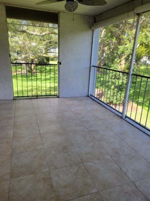 A screened-in balcony features light-colored tile flooring, a ceiling fan, and metal railings — 1808 NORTHLAKE DRIVE UNIT 1808, SANFORD, FL