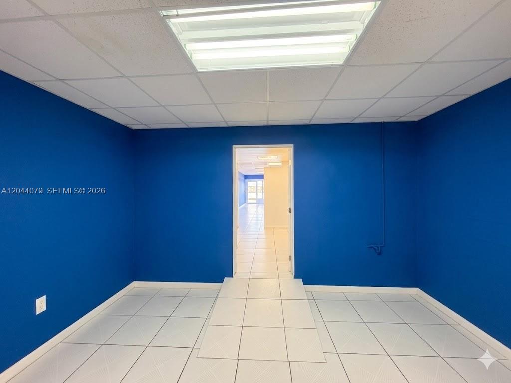 A small room with bright blue walls, white tiled floors, and a drop ceiling — 3130 NW 7th St # 3132, Miami FL 33125, MIAMI, FL