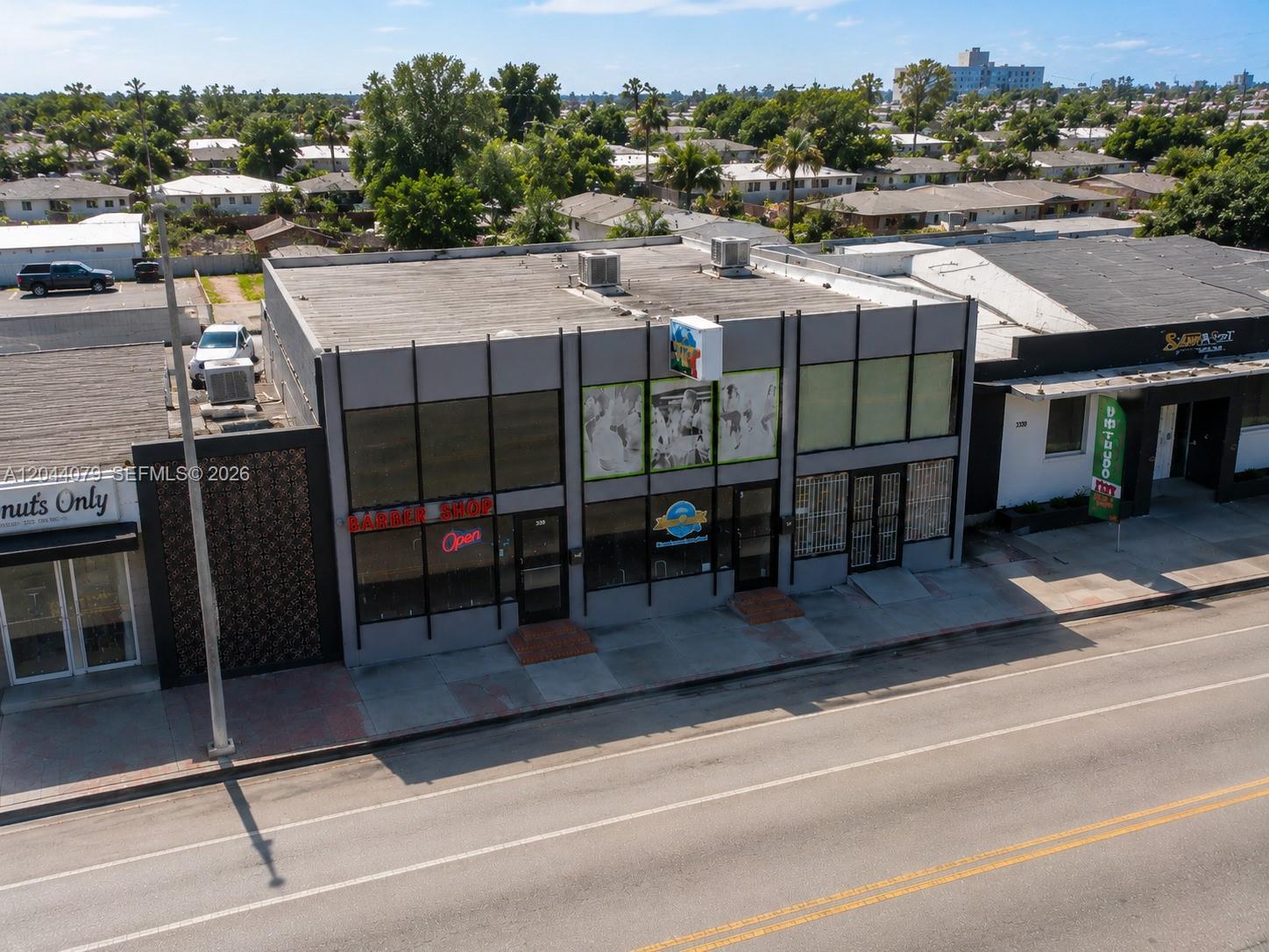 An aerial view shows a gray commercial building with a barber shop and storefronts — 3130 NW 7th St # 3132, Miami FL 33125, MIAMI, FL