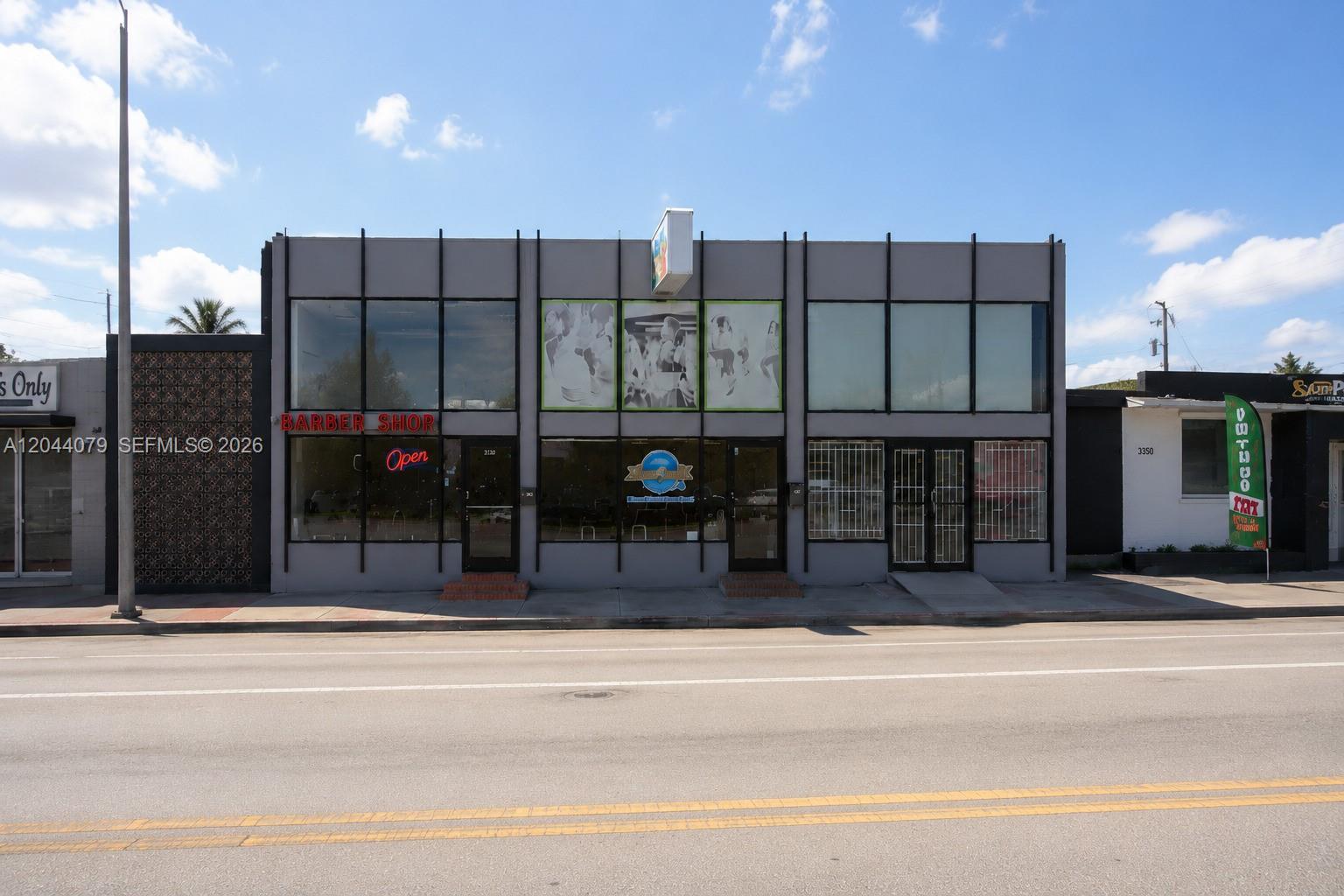 A gray commercial building with large windows and a barber shop sign sits roadside — 3130 NW 7th St # 3132, Miami FL 33125, MIAMI, FL
