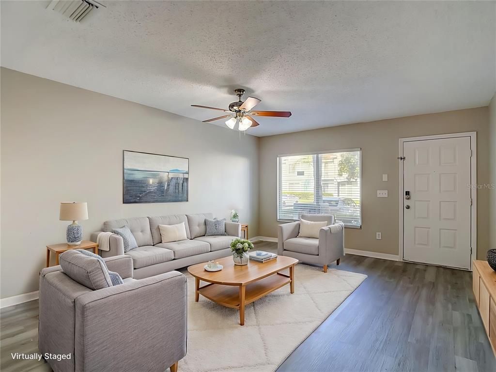 A living room with gray furniture, a wooden coffee table, and a white area rug — 2245 FLUORSHIRE DRIVE, BRANDON, FL