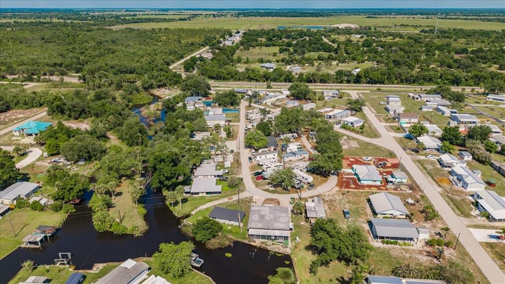 An aerial view shows a residential community with mobile homes situated near a winding canal — 29208 SNOOK CIRCLE, PUNTA GORDA, FL