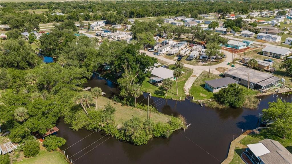 An aerial view shows a residential neighborhood with mobile homes situated along a winding canal — 29208 SNOOK CIRCLE, PUNTA GORDA, FL