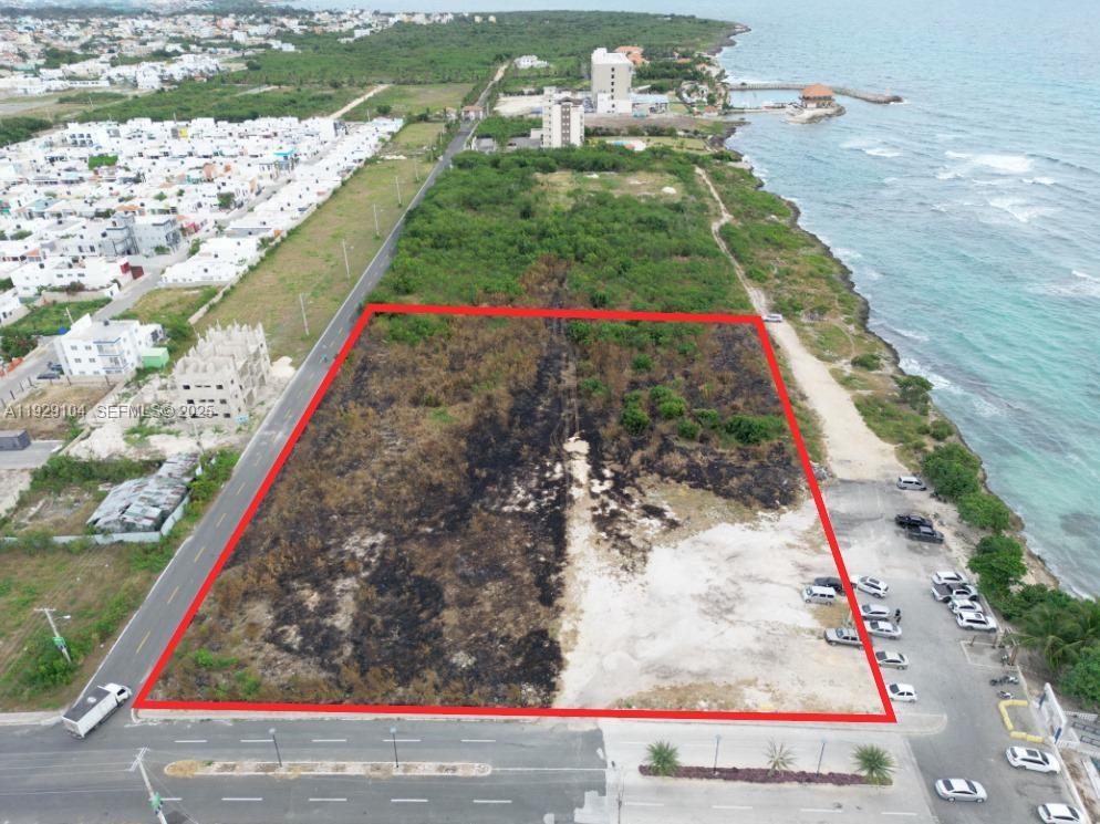 An aerial view shows a rectangular vacant lot bordered by a road and the ocean — Villa Caleta, La Romana, Dominican Republic, DR, DR