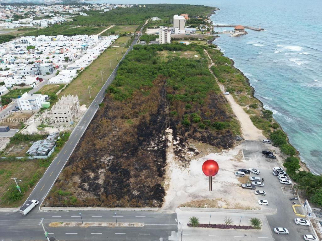 An aerial view shows a vacant coastal lot with a red location pin marker — Villa Caleta, La Romana, Dominican Republic, DR, DR