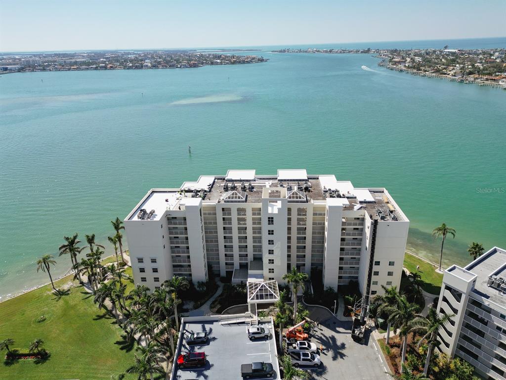 An aerial view shows a multi-story waterfront condominium building surrounded by palm trees and water — 6105 BAHIA DEL MAR CIRCLE UNIT 682, ST PETERSBURG, FL