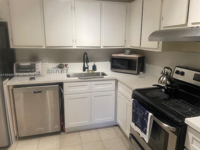 A kitchen features white cabinets, stainless steel appliances, and light-colored countertops — 9002 SW 137 ST # 27, Miami FL 33176, MIAMI, FL