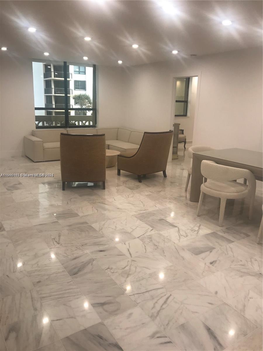 A living and dining area features marble floors, recessed lighting, and a neutral sectional sofa — 10185 Collins Ave # 516, Bal Harbour FL 33154, BAL HARBOUR, FL