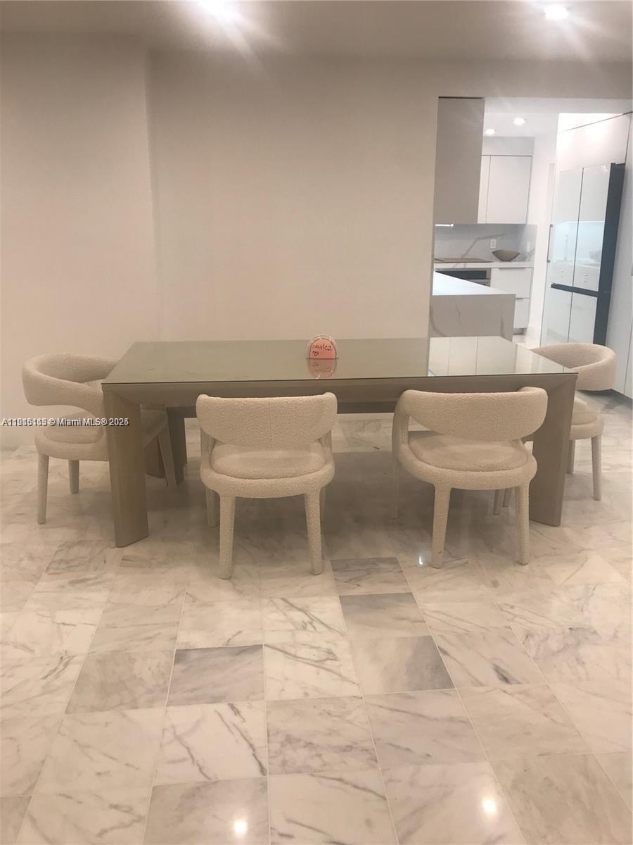 A dining area features a glass-topped table, four cream-colored chairs, and white marble flooring — 10185 Collins Ave # 516, Bal Harbour FL 33154, BAL HARBOUR, FL