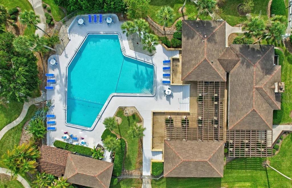 An aerial view shows a swimming pool with lounge chairs next to a building complex — 42 CLUB HOUSE DRIVE UNIT 207, PALM COAST, FL