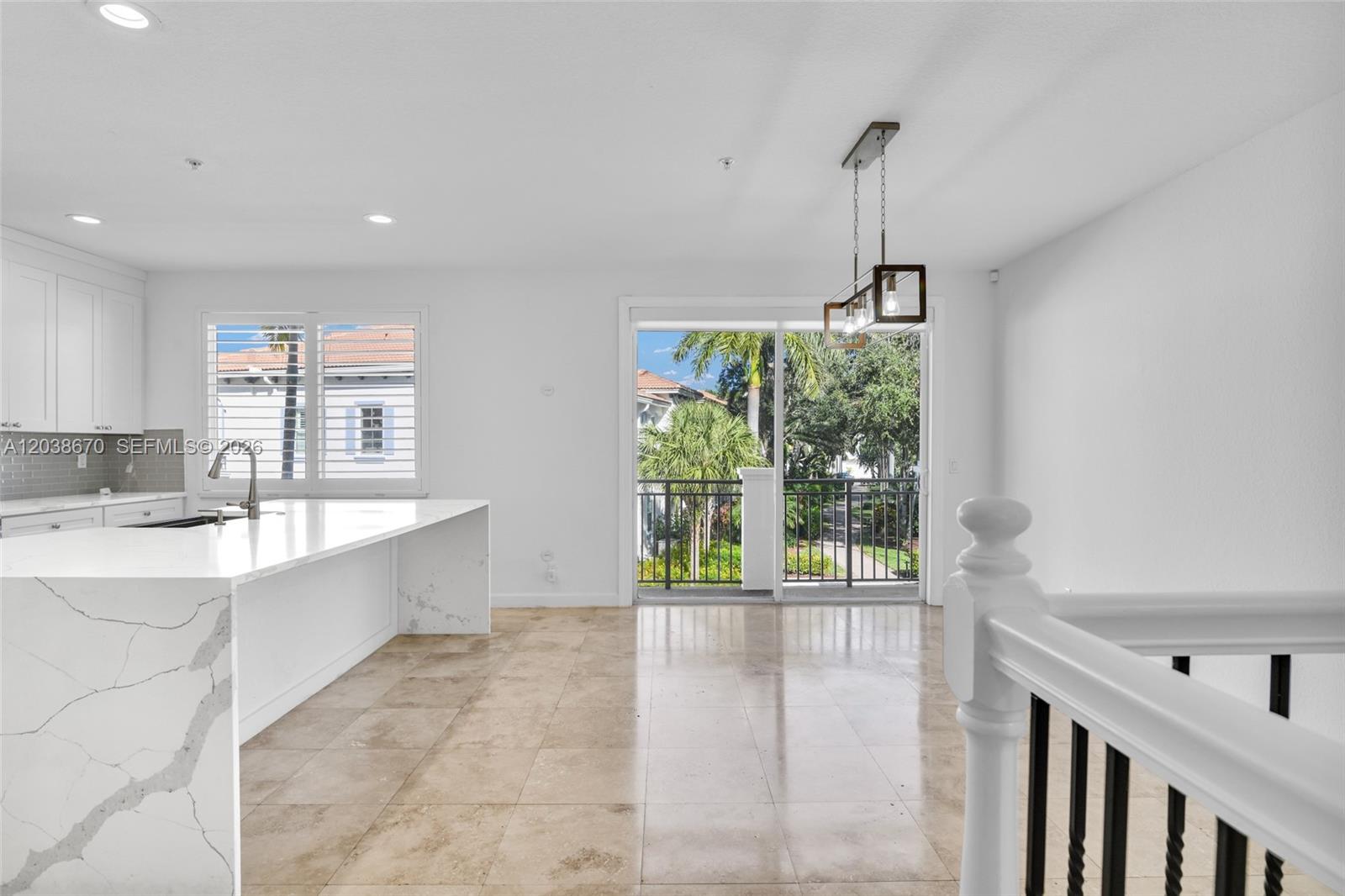 A kitchen with a white marble island and tile floors opens to a balcony view — 3127 Waterside Cir, Boynton Beach FL 33435, BOYNTON BEACH, FL