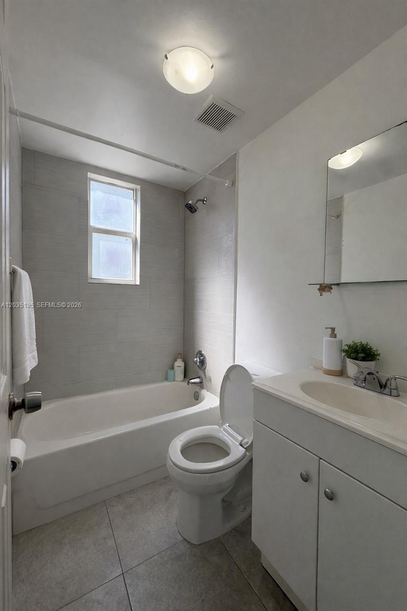 A bathroom features a white vanity, a toilet, and a bathtub with a tiled surround — 540 NW 7th St # 49, Miami FL 33136, MIAMI, FL
