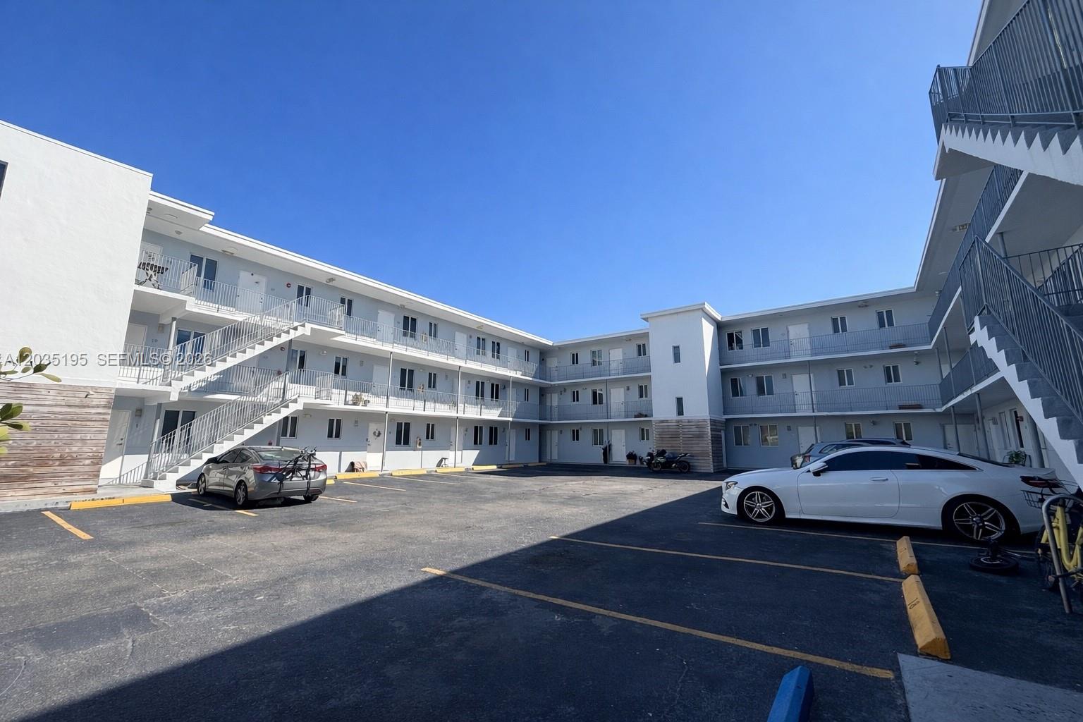 An exterior view of a multi-story apartment building with an open parking lot — 540 NW 7th St # 49, Miami FL 33136, MIAMI, FL