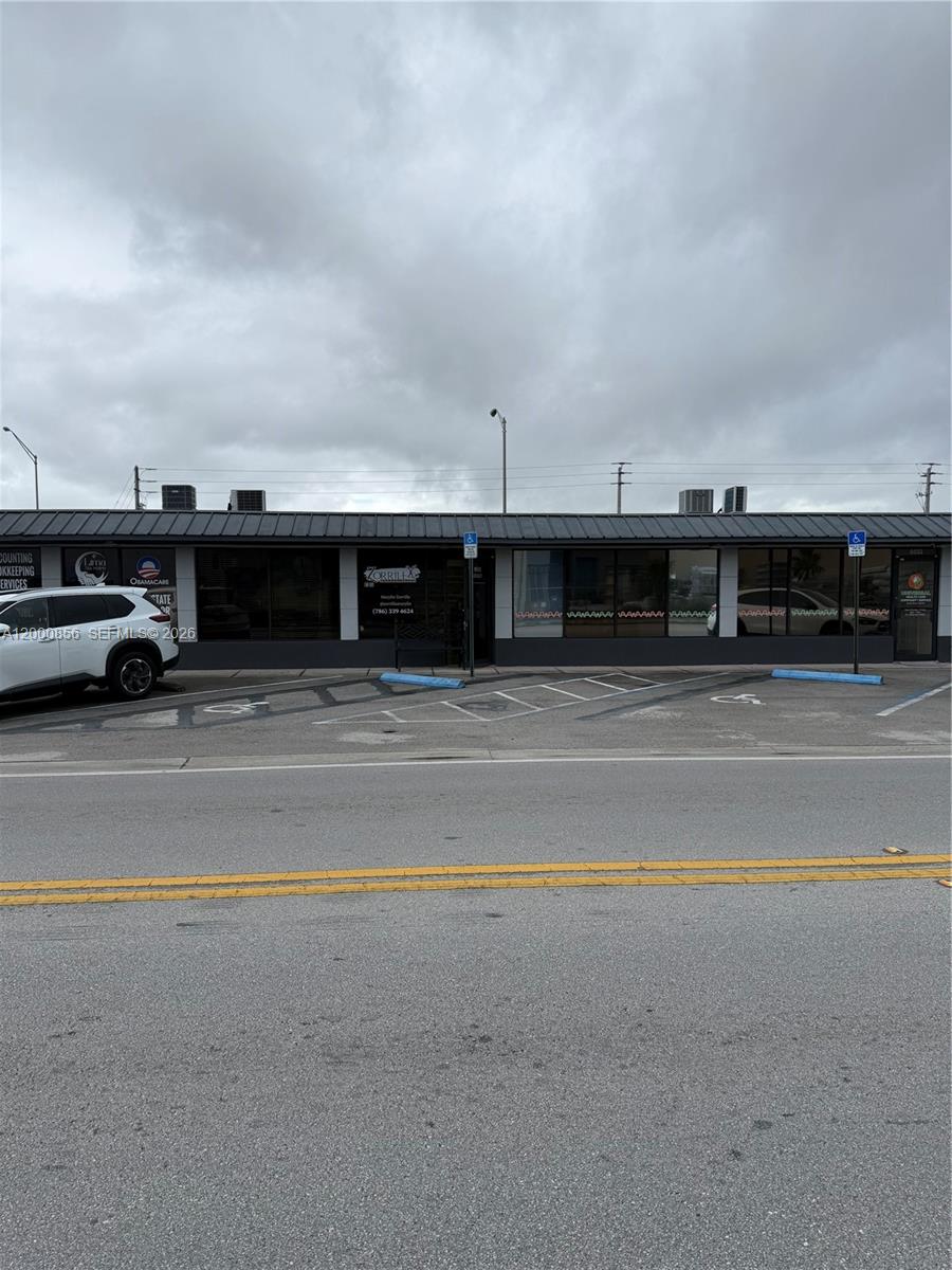 A single-story commercial building with a parking lot in front under a cloudy sky — 8511 NW South River Dr, Medley FL 33166, MEDLEY, FL