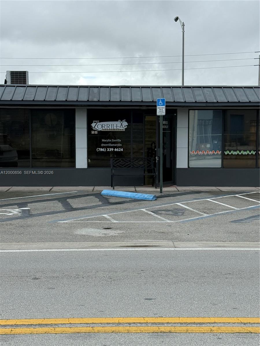 The exterior of a commercial storefront features a dark gray facade, glass windows, and signage — 8511 NW South River Dr, Medley FL 33166, MEDLEY, FL