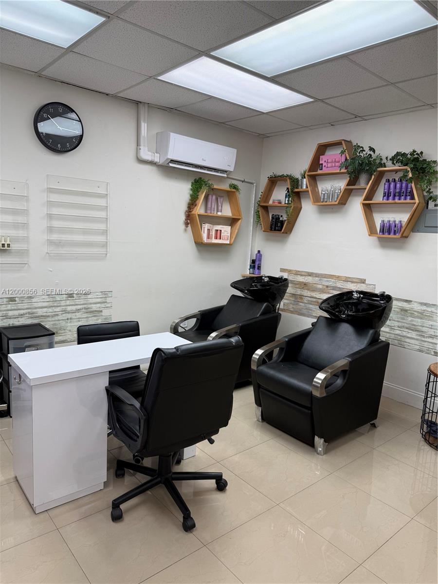 A salon room features two black shampoo stations, a white desk, and hexagonal wall shelving — 8511 NW South River Dr, Medley FL 33166, MEDLEY, FL