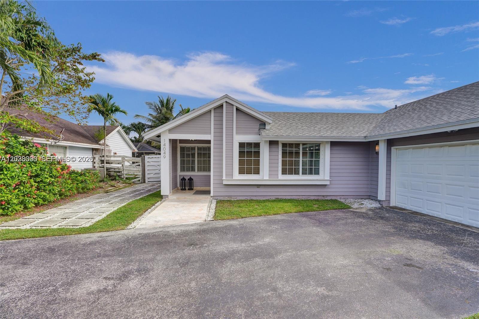 A light purple house with a white-trimmed entrance, a garage, and a paved driveway — 14049 SW 103rd Ter # 1, Miami FL 33186, MIAMI, FL