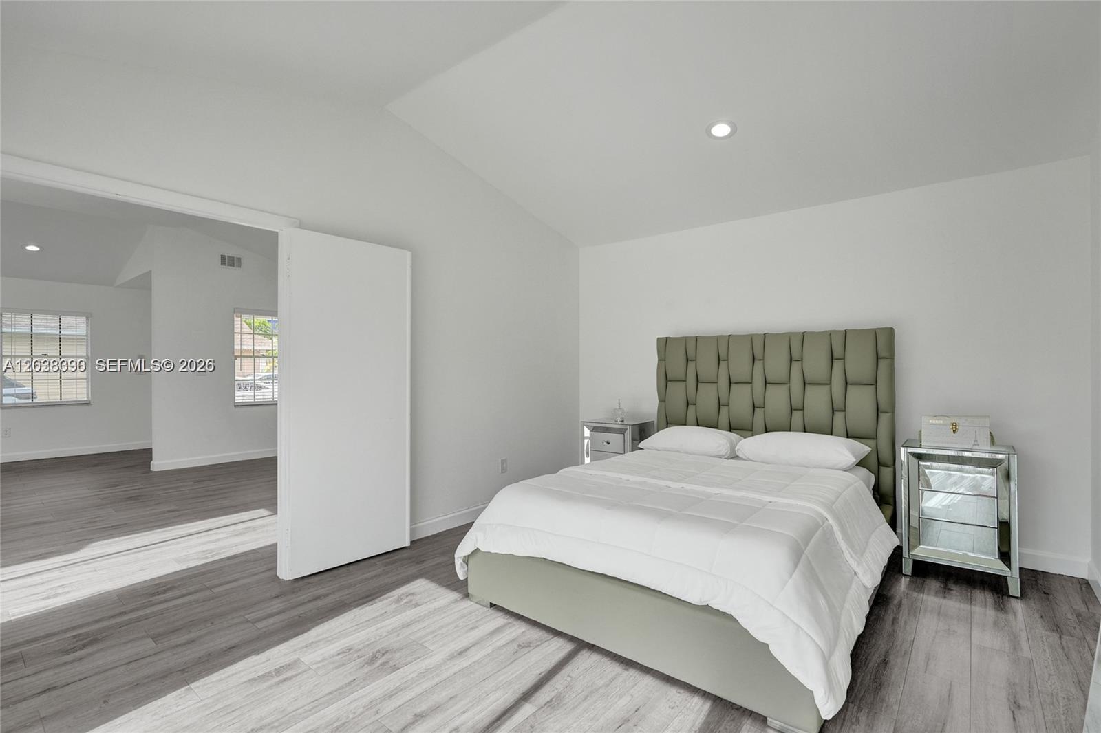 A bedroom features a tufted green headboard, mirrored nightstands, and light gray wood-look flooring — 14049 SW 103rd Ter # 1, Miami FL 33186, MIAMI, FL