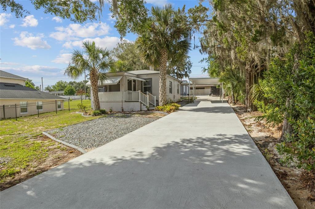 A single-story house with a screened porch, a concrete driveway, and a carport — 205 W MAPLE STREET, DAVENPORT, FL