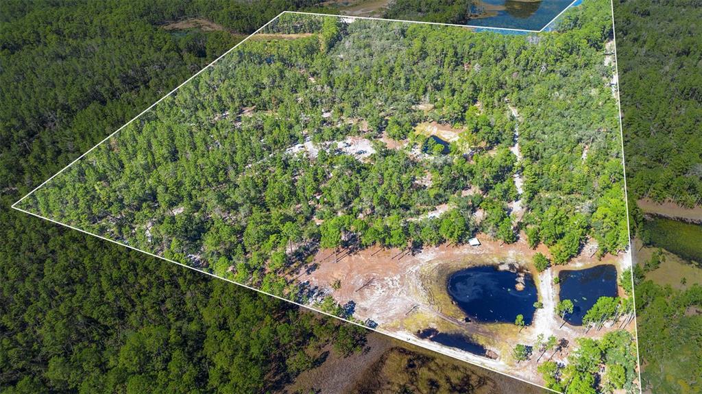 An aerial view of a large, wooded plot of land featuring two ponds and clearings — DEEP WOODS ROAD, PAISLEY, FL