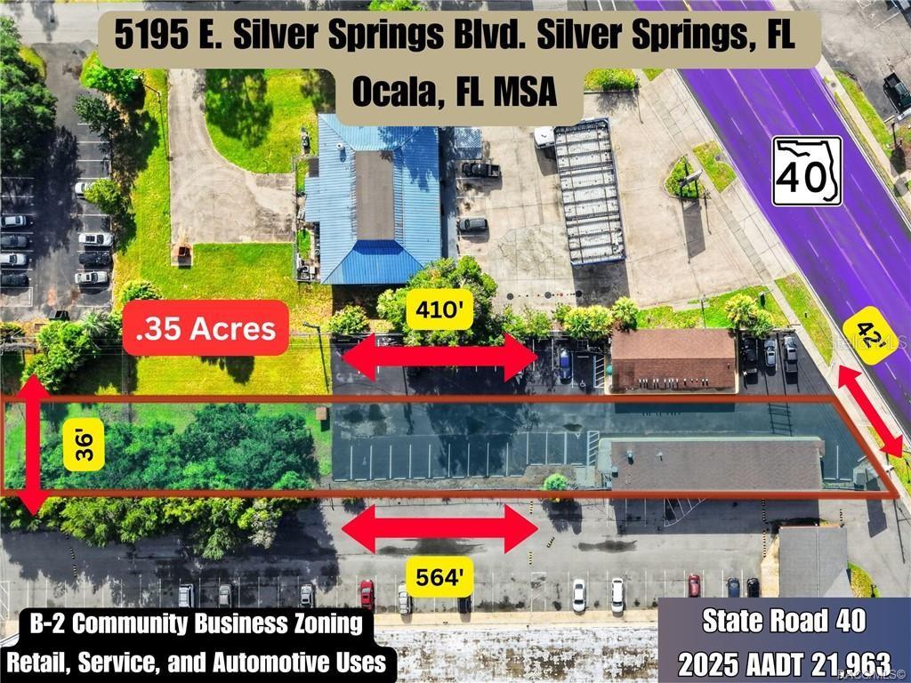 This aerial view shows a commercial property with parking lots and buildings along a road — 5195 E SILVER SPRINGS BOULEVARD, SILVER SPRINGS, FL