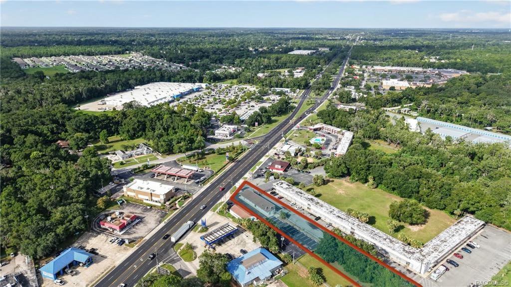An aerial view shows a long commercial building outlined in red next to a road — 5195 E SILVER SPRINGS BOULEVARD, SILVER SPRINGS, FL