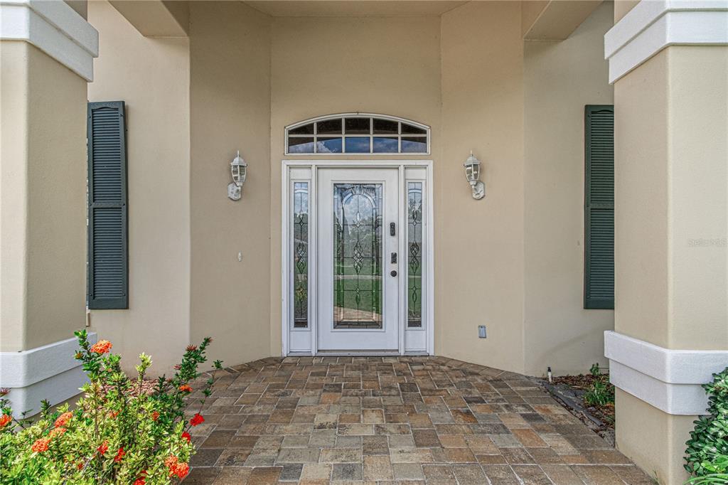 A front entryway features a glass-paneled door with sidelights and a transom window — 800 STERLING CHASE DRIVE, PORT ORANGE, FL