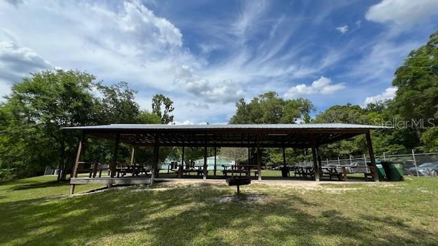 A large, open-air wooden picnic pavilion sits on a grassy lawn under a blue sky — SW BUMBLE STREET, FORT WHITE, FL