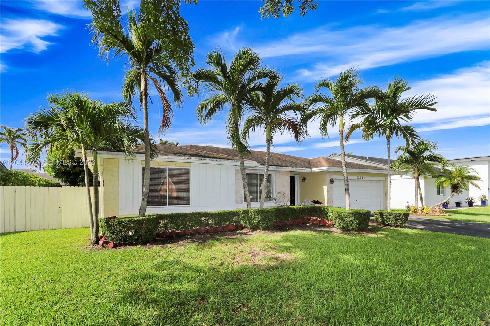 A single-story house with a white facade, palm trees, and a manicured lawn — 12730 SW 119th St, Miami FL 33186, MIAMI, FL