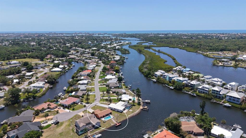 An aerial view shows a waterfront house with a pool and dock on a canal — 723 PORTIA STREET N, NOKOMIS, FL