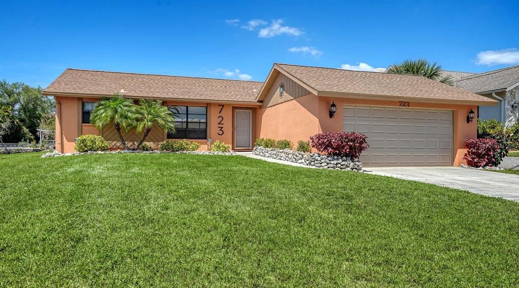 A single-story house with a tan stucco exterior, brown roof, and a two-car garage — 723 PORTIA STREET N, NOKOMIS, FL