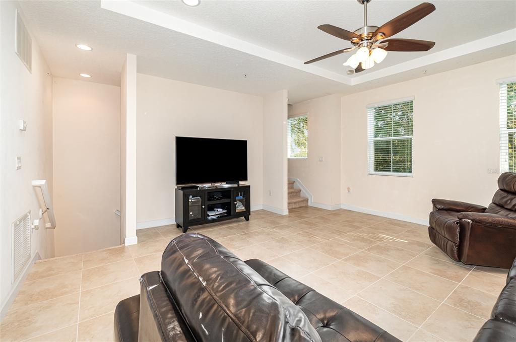 A living room with tile floors, a ceiling fan, and a television on a stand — 669 HANGNEST LANE, LAKE MARY, FL