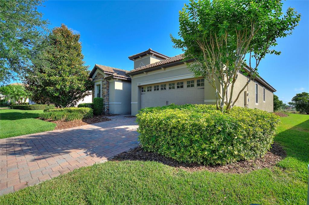 A single-story house with a paved driveway, a two-car garage, and a manicured front lawn — 1379 PALMETTO DUNES STREET, DAVENPORT, FL