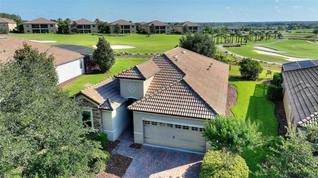 An aerial view shows a single-story house with a tiled roof and a golf course — 1379 PALMETTO DUNES STREET, DAVENPORT, FL