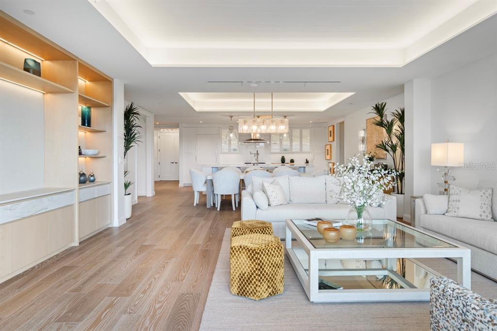 A bright, open-concept living and dining area features light wood floors and modern recessed lighting — 10160 AUTUMN MIST LANE UNIT 402, ORLANDO, FL