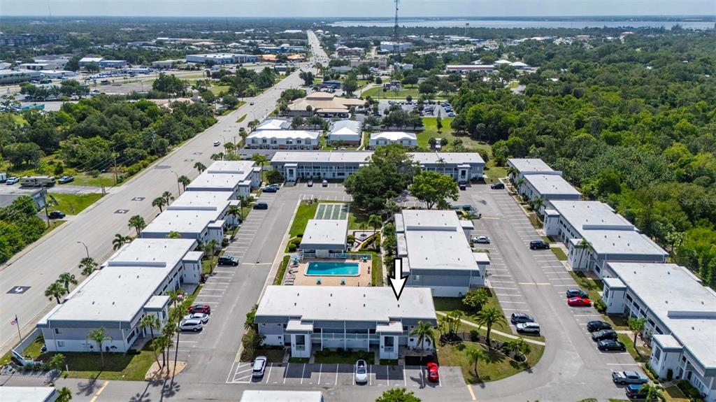 An aerial view shows a multi-building apartment complex with a central swimming pool and parking — 22375 EDGEWATER DRIVE UNIT 123, PORT CHARLOTTE, FL