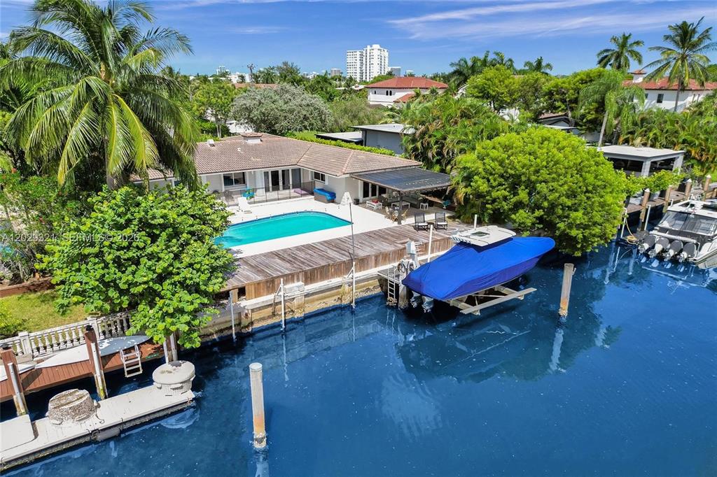 An aerial view of a waterfront house with a swimming pool and a boat lift — 1912 NE 119TH ROAD, NORTH MIAMI, FL