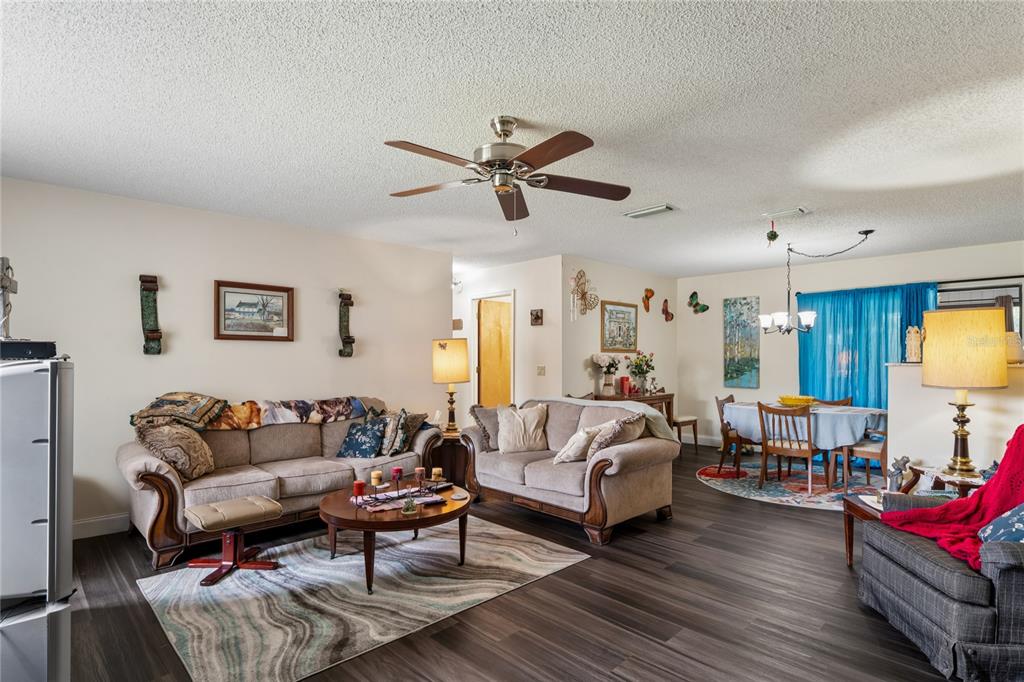 A living room and dining area with wood-look flooring, a ceiling fan, and neutral walls — 1904 W BELGRADE DRIVE, CITRUS SPRINGS, FL