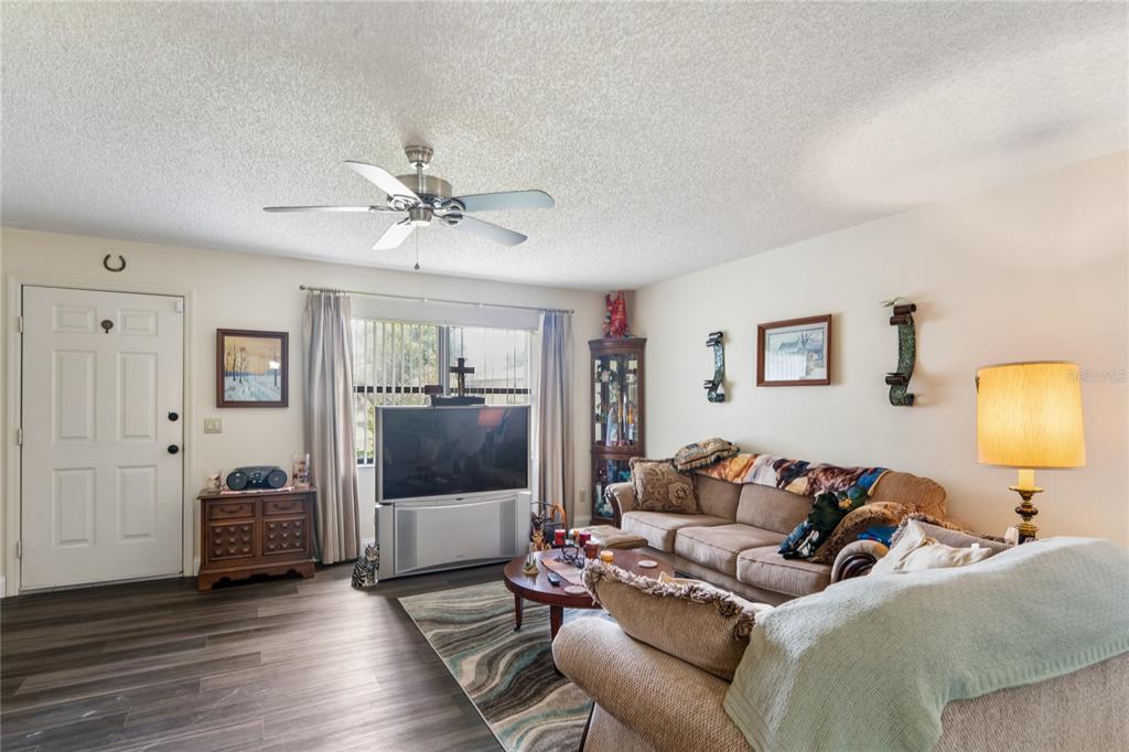 A living room features a ceiling fan, wood-look flooring, a sofa, and a television — 1904 W BELGRADE DRIVE, CITRUS SPRINGS, FL