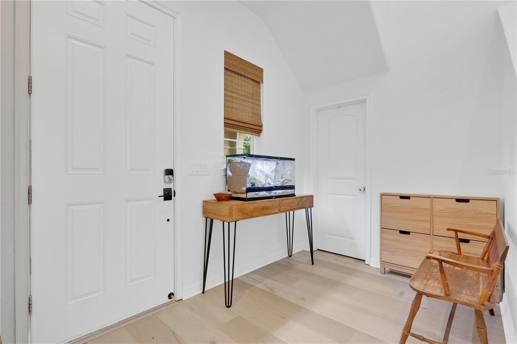 An entryway features a white door, a wooden console table with a terrarium, and storage cabinets — 17059 HARBOR OAK PARKWAY, WINTER GARDEN, FL