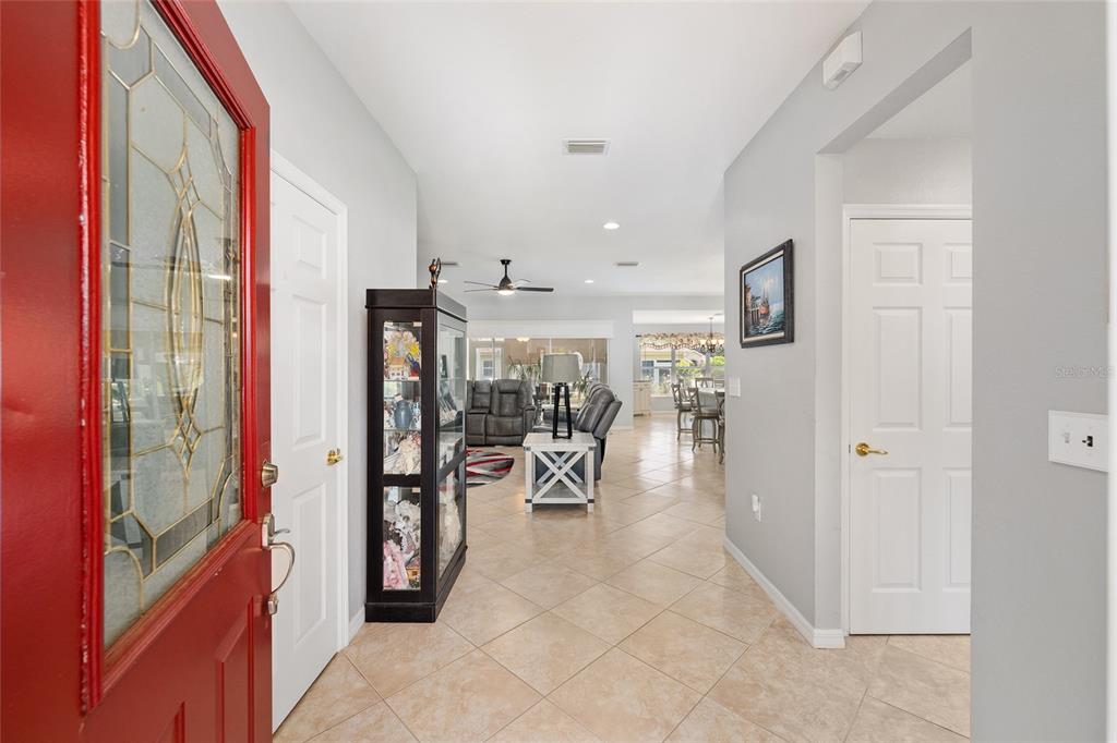 An entryway with a red front door leads into a tiled living area — 12603 SE 90TH TERRACE, SUMMERFIELD, FL