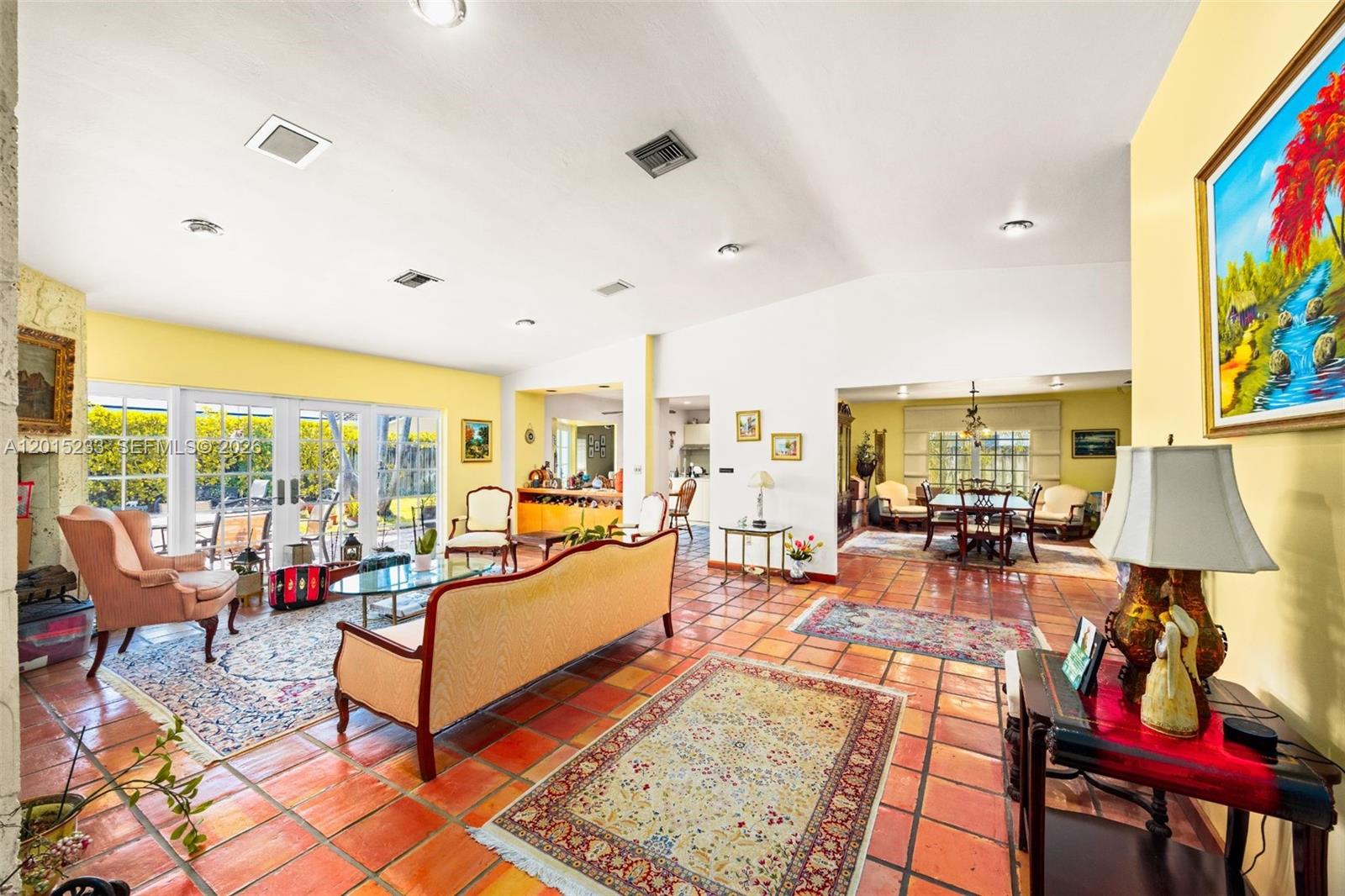 A spacious living and dining area features terracotta tile floors and large glass sliding doors — 21141 NE 21st Ct, Miami FL 33179, MIAMI, FL