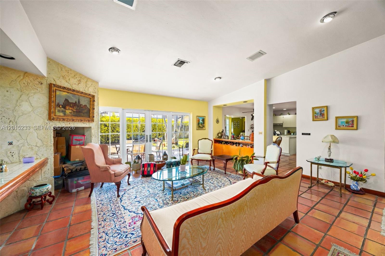 A living room features a stone fireplace, tile flooring, and glass doors leading outside — 21141 NE 21st Ct, Miami FL 33179, MIAMI, FL