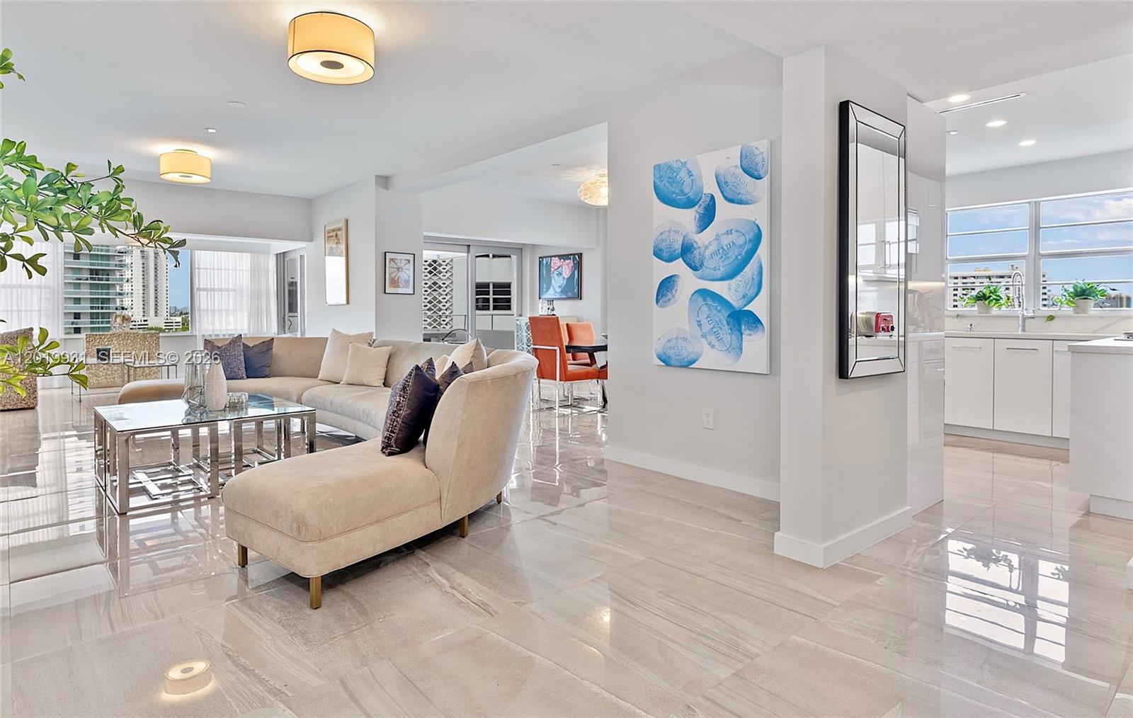 A bright, open-concept living area features polished tile floors, a sectional sofa, and a kitchen — 16 Island Ave # 7C, Miami Beach FL 33139, MIAMI BEACH, FL
