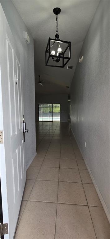 A tiled entryway leads into a living area with a view of a screened pool — 334 RESERVE DRIVE, DAVENPORT, FL